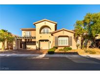 Charming home featuring an arched balcony, three-car garage, and desert landscaping at 10002 Trapper Mountain St, Las Vegas, NV 89178