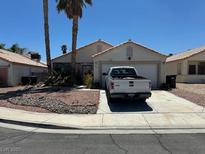 Single story home with white truck in driveway, palm trees, and low maintenance landscaping at 1409 Velvet Leaf Dr, North Las Vegas, NV 89032