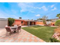 Spacious backyard featuring green lawn, covered patio, and outdoor seating area at 147 Cervantes St, Las Vegas, NV 89101