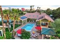 Stunning aerial view of a backyard featuring a sparkling pool, outdoor seating, and lush landscaping with solar panels at 2822 Ashby Ave, Las Vegas, NV 89102