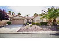 Charming single-story home with desert landscaping, mature palm trees, and a two-car garage at 66 Sunset Bay St, Las Vegas, NV 89148