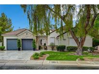 Charming single-story home featuring a stone facade, well-manicured lawn, and a three-car garage at 729 Sir James Bridge Way, Las Vegas, NV 89145