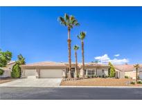 Charming single-story home featuring desert landscaping, palm trees and a two-car garage at 7410 Bridlehorne Ave, Las Vegas, NV 89131
