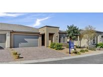 Charming single-story home with a neutral color scheme, desert landscaping, and a brick driveway at 9903 Spinel Pl, Las Vegas, NV 89143