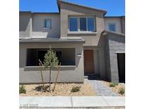 Contemporary townhouse featuring desert landscaping and a neutral color palette at 11407 Ethereal Landing Ave, Las Vegas, NV 89138