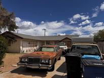 House exterior featuring a driveway with multiple cars parked in front and some trash bins at 212 Hinkle St, Las Vegas, NV 89107