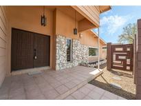Inviting front entrance with double doors, stone accent wall, and decorative hanging lanterns at 2809 Mason Ave, Las Vegas, NV 89102