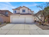 Inviting two-story home with a tile roof, a two-car garage, and a wide driveway under a bright blue sky at 3389 Commendation Dr, Las Vegas, NV 89117
