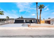 Charming single-story home with a dark-gray two-car garage and low maintenance desert landscaping at 4442 Bennett Dr, Las Vegas, NV 89121