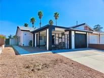 Charming single-story home featuring a modern black and white carport, desert landscaping, and a clear blue sky backdrop at 4681 Via San Rafael, Las Vegas, NV 89103