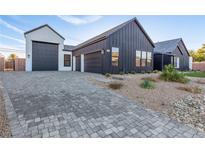 Modern home showcasing a stylish garage and a paved driveway, with desert landscaping at 5725 El Royale Ct, Las Vegas, NV 89149