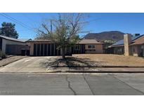 Single-story home featuring a two-car garage and low desert landscaping at 613 Buchanan Ave, Henderson, NV 89015