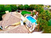 Expansive backyard boasts a pool, lush landscaping, and a charming pergola for outdoor relaxation and entertaining at 8138 Yucca Springs Dr, Las Vegas, NV 89129