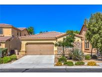 Charming single-story home featuring a two-car garage, desert landscaping, and stone facade accents at 8247 Oasis Bloom St, North Las Vegas, NV 89085