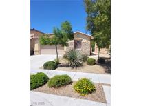 Charming home with desert landscaping, including shrubs, trees, and a rock garden, creating an inviting curb appeal at 8247 Oasis Bloom St, North Las Vegas, NV 89085