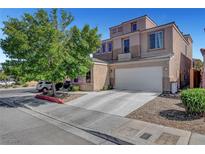 Two-story home with tan stucco, three-car garage, and mature shade tree in front yard at 9065 W Torino Ave, Las Vegas, NV 89148