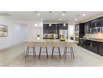 Spacious kitchen features dark cabinets, stainless steel appliances, and a large center island with seating at 10742 Cowlite Ave, Las Vegas, NV 89166