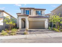 Two story home featuring neutral colored exterior, red tile roof, and two car garage at 10851 Hanwicke Harbor Ave, Las Vegas, NV 89166