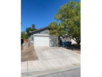 A single-story home with a large driveway and a white garage door at 1841 Skywood Way, Las Vegas, NV 89142