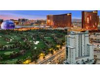 Striking aerial view showcasing the Las Vegas skyline, golf course, and modern building architecture at dusk at 360 E Desert Inn Rd # 1901, Las Vegas, NV 89109