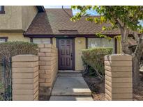 Charming townhome featuring a well-kept front yard with mature landscaping and a welcoming brown front door at 4571 Sirius Ave, Las Vegas, NV 89102