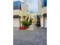 Exterior of a condo featuring stucco, private garages and stairs to the upper levels at 5029 Spencer St # D, Las Vegas, NV 89119