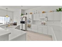 Bright kitchen featuring white cabinetry, a built-in oven, and sleek countertops, creating a clean and modern culinary space at 6141 Markleham Ave, Las Vegas, NV 89130