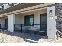Inviting front porch with stone accents and a secure metal railing leading to the entrance at 835 Jigglypuff Pl, Henderson, NV 89011