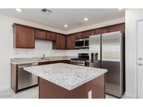 Modern kitchen features granite countertops, stainless steel appliances, and custom cabinetry at 835 Jigglypuff Pl, Henderson, NV 89011