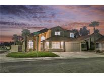 Charming two-story home with desert landscaping and a two-car garage under a beautiful evening sky at 8401 Airmont Ct, Las Vegas, NV 89128