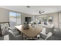 Bright, airy living and dining room featuring modern furnishings, large windows, and neutral tones at 10201 Premia Pl, Las Vegas, NV 89135