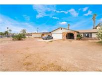 Charming single-story home featuring a two-car garage, a stone-accented entryway and desert landscaping at 1733 N Michael Way, Las Vegas, NV 89108