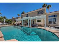 Backyard pool with tanning ledge, mature landscaping, and covered patio area at 2016 Catalina Marie Ave, Henderson, NV 89074
