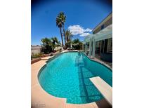 Inviting backyard pool with diving board, shaded patio, and lush landscaping for outdoor enjoyment at 2016 Catalina Marie Ave, Henderson, NV 89074