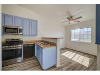 Bright kitchen features stainless steel appliances, blue cabinetry, and wood-look flooring at 3318 N Decatur Blvd # 2129, Las Vegas, NV 89130