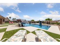 Inviting backyard oasis with a sparkling pool, lounge chairs, and lush landscaping at 3955 W Jo Rae Ave, Las Vegas, NV 89141