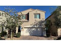 Inviting two-story home with a two-car garage, brick driveway, and desert landscaping at 4752 Cactus Sun Ln, North Las Vegas, NV 89031