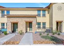 Townhome exterior with stone accents, two stories, and tidy landscaping for a welcoming curb appeal at 1125 Meadow Sparrow Pl, Henderson, NV 89011