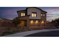 Charming two-story home featuring a three-car garage and desert landscaping at dusk at 1297 Ventura Cliffs Ave, Henderson, NV 89012