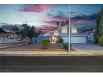 Charming two-story home with a two-car garage and desert landscaping at dusk at 1808 Piccolo Way, Las Vegas, NV 89146