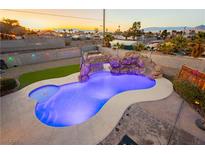 Beautiful pool features a rock waterfall, slide and custom lighting to create a backyard paradise at 200 E Desert Rose Dr, Henderson, NV 89015