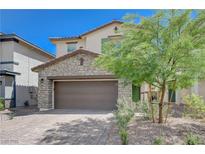 Charming two-story home featuring a stone facade, two-car garage and manicured landscaping at 387 Larksong Ave, Henderson, NV 89011