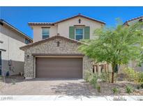 Charming two-story home with a two-car garage, stone accents, and desert landscaping at 387 Larksong Ave, Henderson, NV 89011
