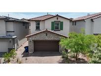 Charming two-story home with a stone-accented garage and terracotta roof tiles at 387 Larksong Ave, Henderson, NV 89011