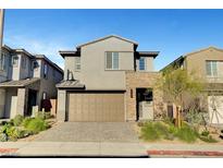 Charming two-story home with a two-car garage and stone accents, enhanced by lush landscaping at 40 Strada Moscato, Henderson, NV 89011