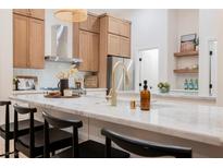 Bright kitchen featuring wood cabinets, stainless appliances, and a stylish marble countertop at 4065 Genoa Dr, Las Vegas, NV 89141