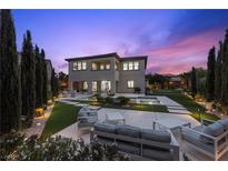 A luxurious backyard featuring a modern pool, patio furniture, and lush landscaping, perfect for outdoor entertaining at 4220 San Alivia Ct, Las Vegas, NV 89141