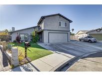 Two-story house featuring a gray exterior, attached garage, and well-maintained front yard with green grass at 4474 Dawley Ct, Las Vegas, NV 89104