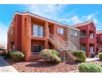 Exterior view of a two-story condo building with desert landscaping and stairs to upper units at 4730 E Craig Rd # 1115, Las Vegas, NV 89115