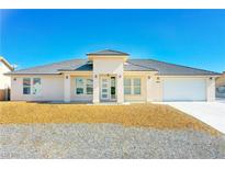Inviting single-story home with modern design, desert landscaping, and a spacious two-car garage at 5400 E Grain Mill Rd, Pahrump, NV 89061
